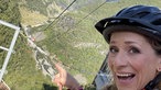 Tamina Kallert mit Schutzhelm hoch oben am Startpunkt der Zipline