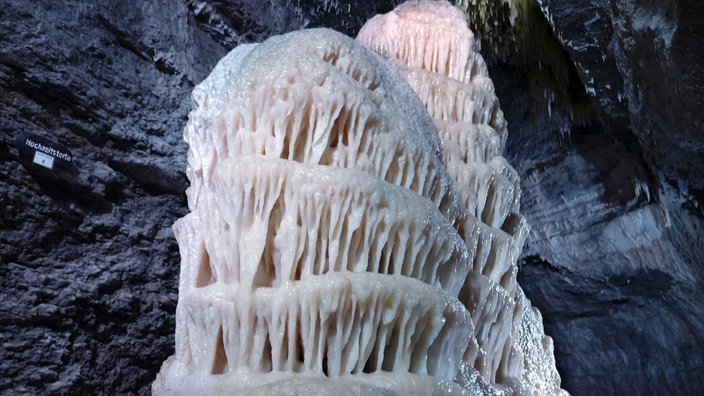 Ein Stalagmit in einer Höhle, dessen Form an eine Torte erinnert