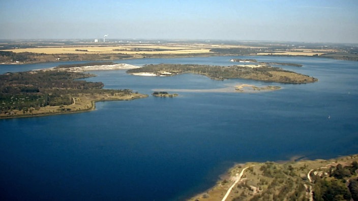 Blick von oben auf einen großen Tagebausee mit Inseln