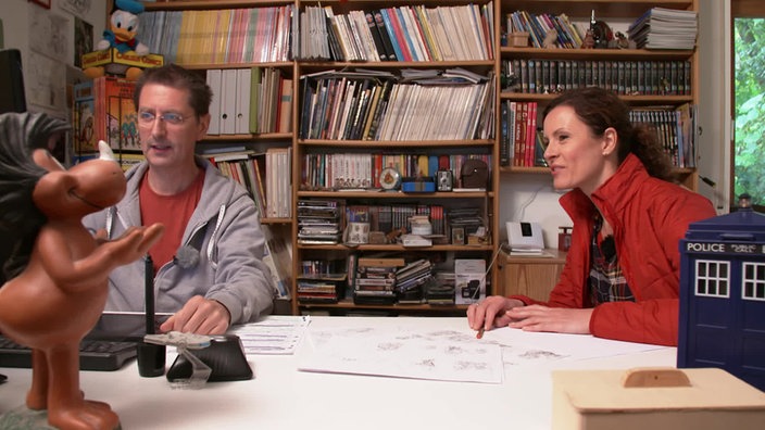 Anne Willmes und Matthias Kringe sitzen im Büro an einem Tisch