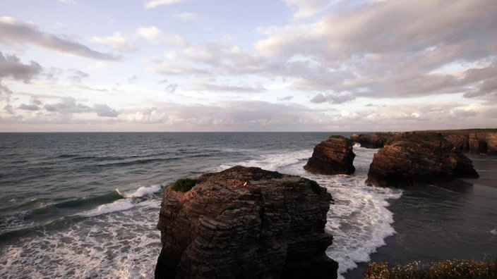 Emporragende Felsen am flachen Strand