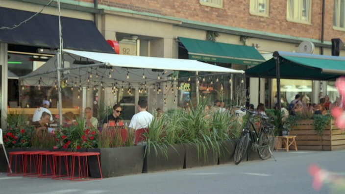 Junge Leute sitzen in Straßencafés