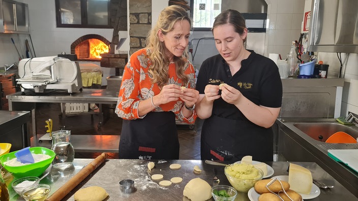 Tamina Kallert (l)und Eleonora Ennas stehen in einer Küche 