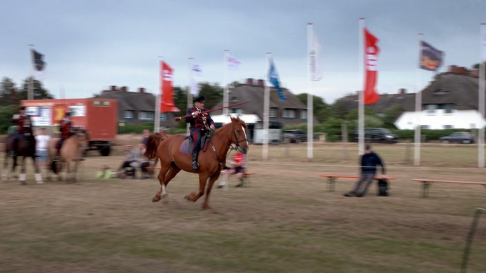 Reiter mit Lanze beim traditionellen Keitumer Ringreiten