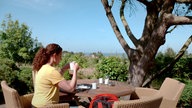 Anne Willmes sitzt an einem Tisch im Garten von Café Kupferkanne