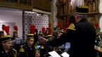 Bergmänner in Uniform spielen auf Blasinstrumenten in einer Kirche