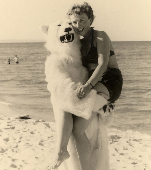 Ein Mensch im Eisbärkostüm hebt eine Frau im Bikini hoch.