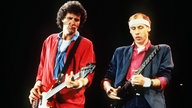 Der Sänger Mark Knopfler (r) der bitischen Rockgruppe "Dire Straits" mit dem Bassisten John Illsley bei einem Auftritt in Helsinki/Finnland, 1985