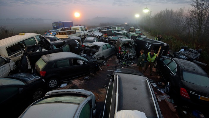 Verunglückte Fahrzeuge stehen an der Unfallstelle einer Massenkarambolage auf der A31