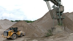 Das Beitragsbild des Dok 5 Feature "Auf Sand gebaut - Konlikt um Sand und Kies", zeigt ein Kieswerk mit Bagger und Förderturm