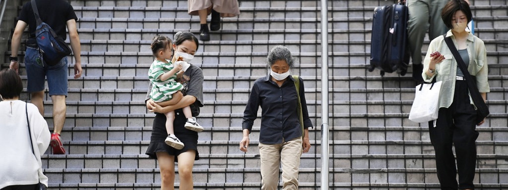 Das Beitragsbild des Dok5 "Alterndes Japan" zeigt eine junge Mutter mit Kind und eine ältere Frau im öffentlichen Raum in Tokyo, Japan 2022.