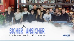 Hinter der Theke des griechischen Restaurants „Kreuzberger Weltlaterne“ stehen die Betriebs- ud Familienmitglieder der Familie Gatidis. Davor steht der Titel "Sicher unsicher" und die Silhouette einer Person, die vom einen Wort zum anderen springt.