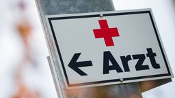 Schild mit einem Pfeil und der Aufschrift "Arzt"