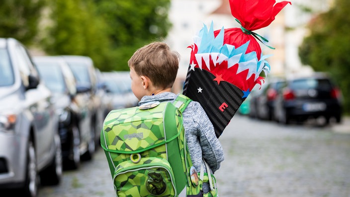 Ein Kind mit Tornister und Schultüte