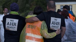 Fluthelfer und mehrere Anwohner nehmen an einem Trauermarsch durch Kreuzberg an der Ahr mit anschließender Menschenkette teil. 