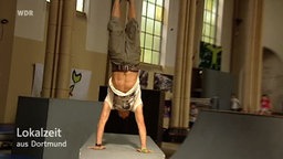 Parcour Teilnehmer macht Handstand