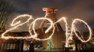 Mit einer brennenden Wunderkerze geschriebene Jahreszahl 2010 vor der Zeche Zollverein