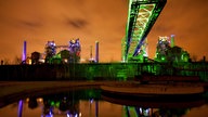 Der Duisburger Landschaftspark Nord bei Nacht mit einer kunstvollen grünen Lichtgestaltung