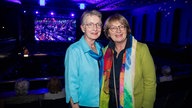 Brigitte Müller-Schellknecht (links) und Gisela Göllner-Kesting (rechts), im Hintergrund ein vollbesetzter Konzertsaal.