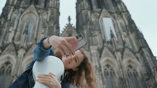 Cellistin Anastasia Kobenika macht ein Selfie vor dem Kölner Dom