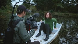 Cellistin Anastasia Kobenika sitzt während eines während eines Videoshoots in einem weißen Ruderboot