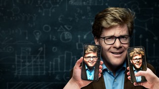 Ein Mann mit Brille steht vor einer Schultafel. Zwei Smartphones werden neben sein Gesicht gehalten, auf denen dasselbe Bild mit verschiedenen humoristischen Filtern gezeigt wird