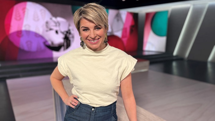 Sabine Heinrich steht im Frau tv Studio und lacht in die Kamera