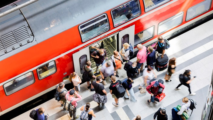 Menschen steigen in eine Regionalbahn ein - Blick aus der Vogelperspektive. 