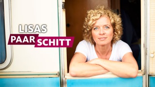 Lisa Ortgies lehnt aus einem Fenster und schaut in die Kamera. 