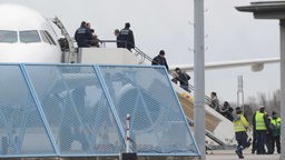 Abgelehnte Asylbewerber steigen im Rahmen einer landesweiten Sammelabschiebung in ein Flugzeug