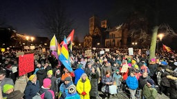 Menschen versammeln sich in Münster zu einer Demo gegen Rechtsextremismus, viele Menschen halten Schilder und Fahnen