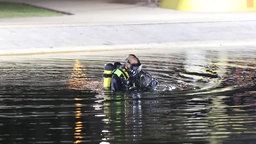 Ein Taucher der Polizei durchsucht ein Wasserbecken in der Grünen Mitte in Essen