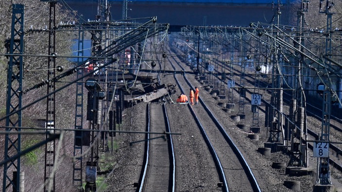 Mitarbeiter der Deutschen Bahn begutachten einen aus den Gleisen gesprungenen Güterwaggon am Bahnhof Langerfeld.