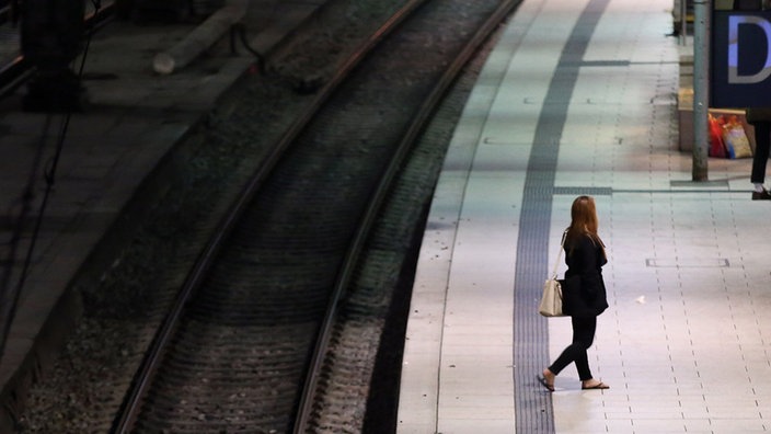 Eine Frau steht am Morgen während des Streiks der Lokführer auf dem Bahnsteig