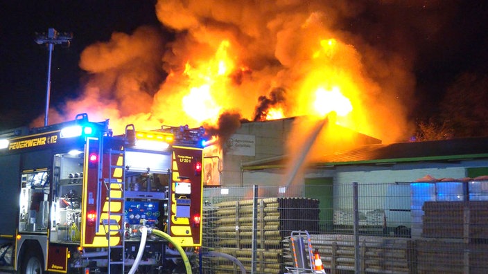 Falmmen schlagen bei einem Großbrand in Hünxe (Kreis Wesel) aus dem Dach einer Gewerbehalle