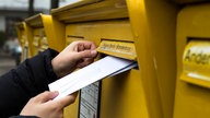 Brief wird in einen Briefkasten eingeworfen