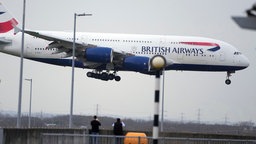 Menschen beobachten die Landung eines Flugzeugs der British Airways