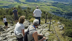 Wandergruppe auf Felsen, weiter Blick ins Tal