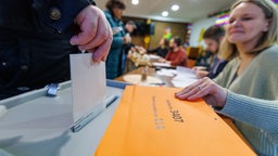 Ein Mann gibt in einem Wahllokal in Duisburg-Großenbaum seine Stimme ab