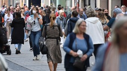 In einer Fußgängerzone drängen sich viele Menschen