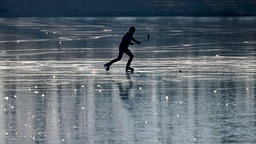 Ein Junge spielt Eishockey auf dem zugefrorenen Decksteiner Weiher