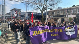 In Essen ziehen Demonstranten mit Fahnen und Plakaten gegen Nazis durch die Straßen