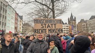 Demonstrantinnen gegen Rechtsextremismus auf dem Heumarkt in Köln mit einem Schild "Menschenrechte statt rechte Menschen"