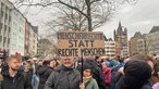 Demonstrantinnen gegen Rechtsextremismus auf dem Heumarkt in Köln mit einem Schild "Menschenrechte statt rechte Menschen"