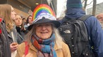 Demonstrantin Carmen Knab aus Köln mit einer Regenbogen-Schirmmütze