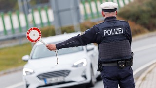 Ein Beamter der Bundespolizei stoppt bei der kontrolle des Einreiseverkehrs am deutsch-tschechischen Grenzübergang 