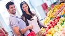 Ein junges Paar kauft im Supermarkt ein.