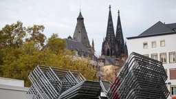 Absperrgitter stehen für den Sessionsstart am 11.11. auf dem Kölner Heumarkt. Im Hintergrund der Dom.