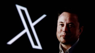 Porträt-Aufnahme von Elon Musk im Hintergrund ist das Logo der Social Media-Plattform "X" zu sehen