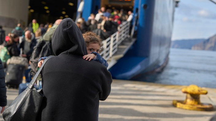 Passagiere besteigen eine reguläre Fähre zum Athener Hafen Piräus.